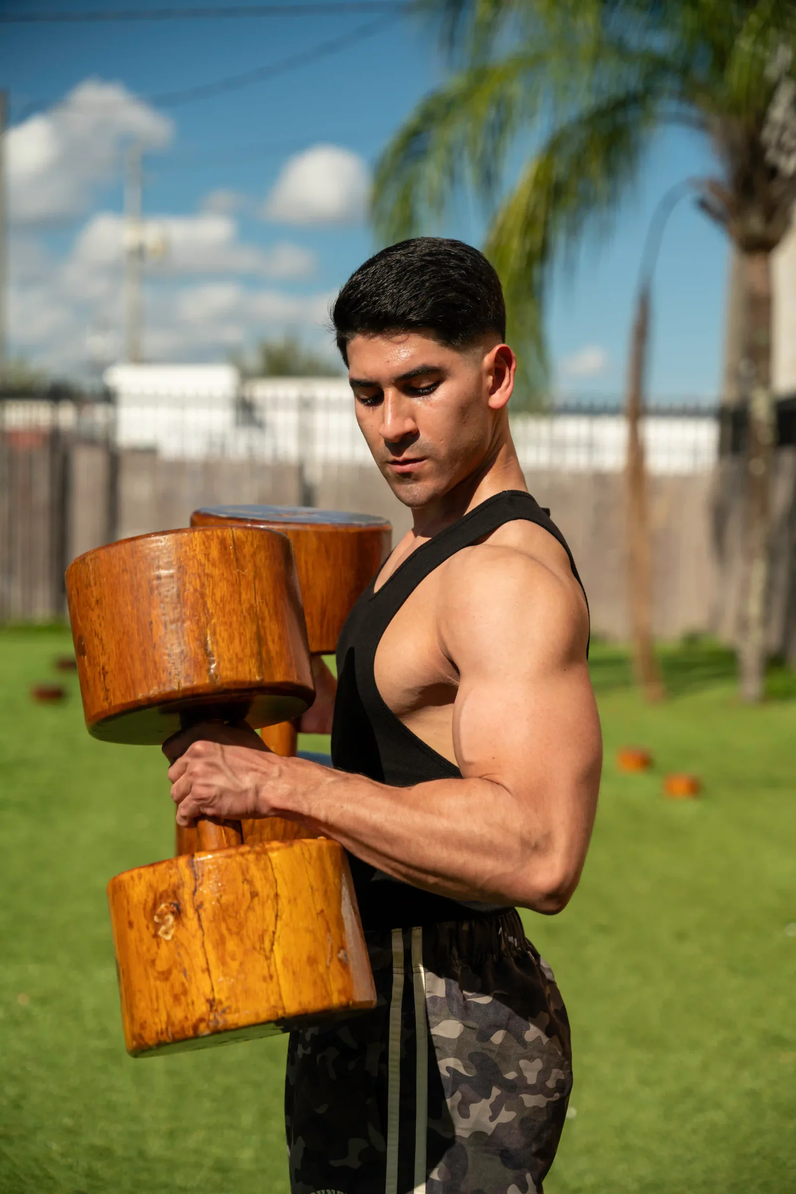 Juan Wagner entrenando al aire libre con una mancuerna de madera